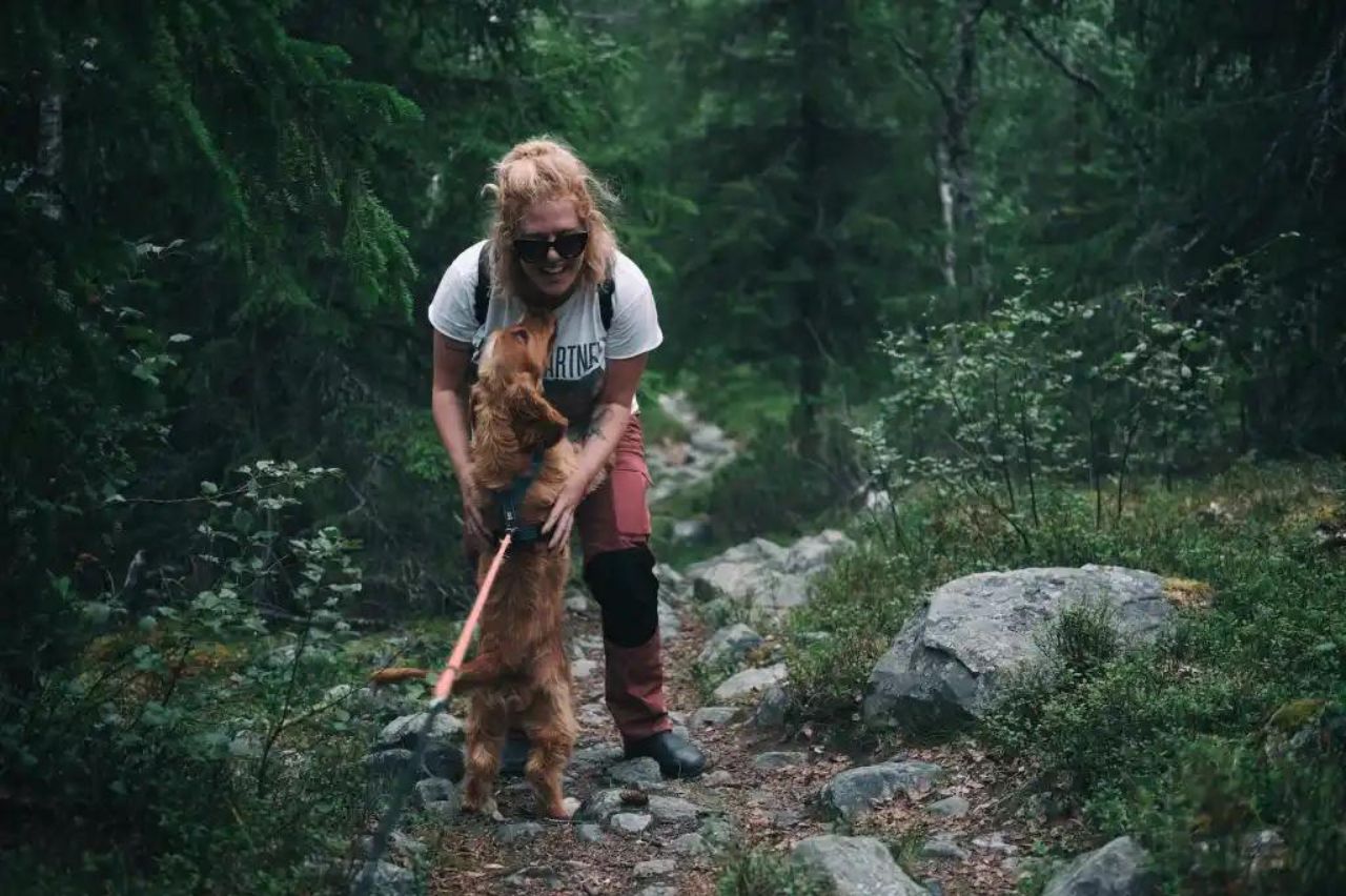 a woman with a dog on a trail