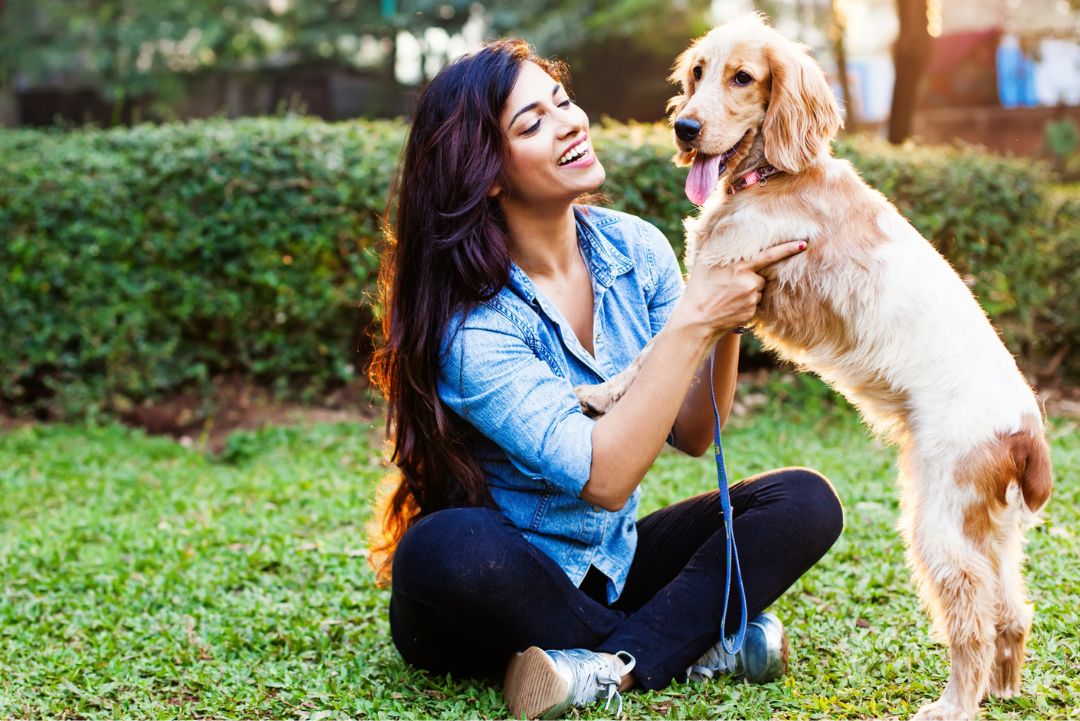 A woman gently pets a dog